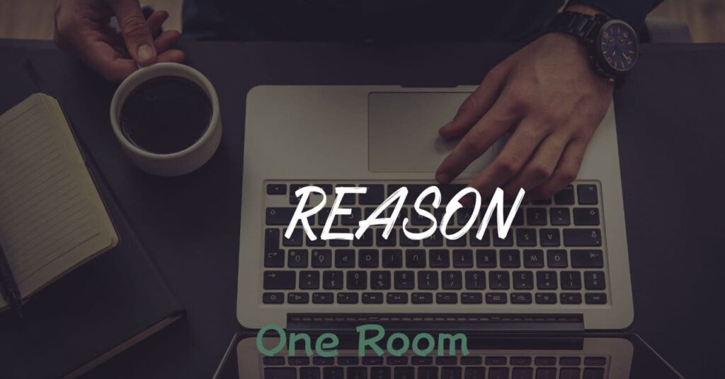 ラップトップの上に「REASON」と書かれた文字と手元、ノートとコーヒーのある作業風景 