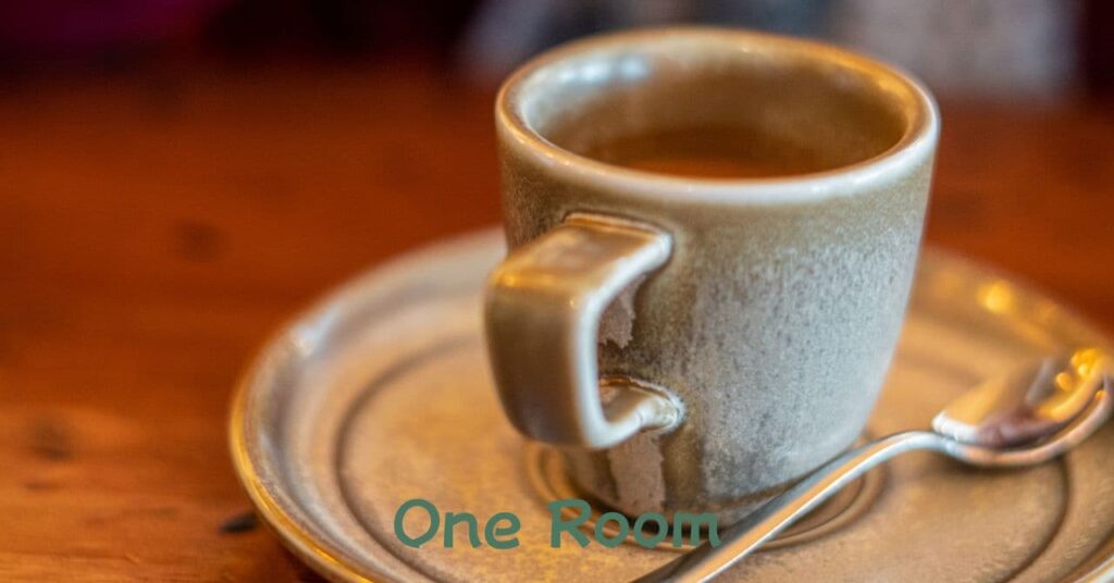 陶器のカップに注がれたコーヒーとスプーンのある温かみのあるテーブル 