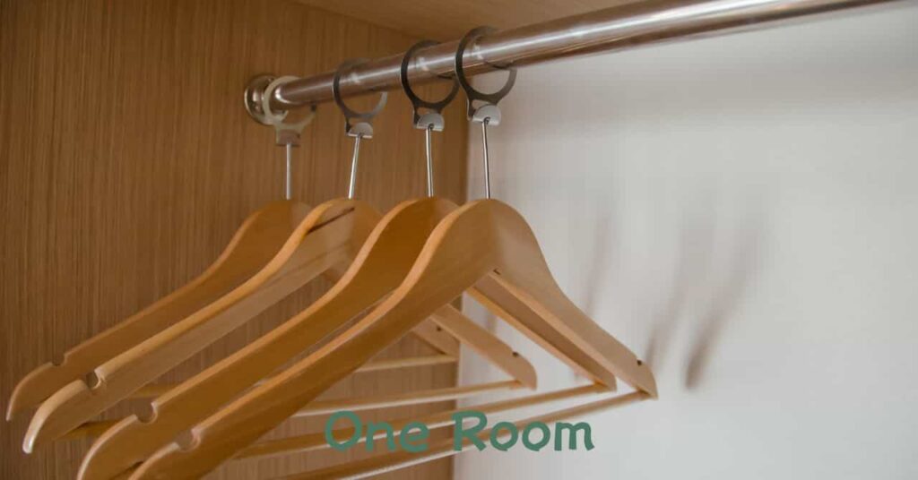 クローゼットに並ぶ木製ハンガー。服の数を可視化して買いすぎを防ぐ工夫を表現した写真。 